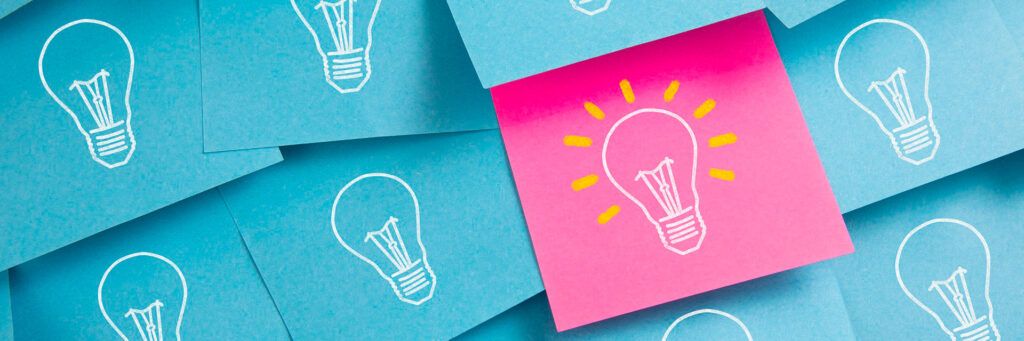 Post-its com lâmpadas desenhadas simbolizando brainstorming, ideias e criatividade colaborativa.