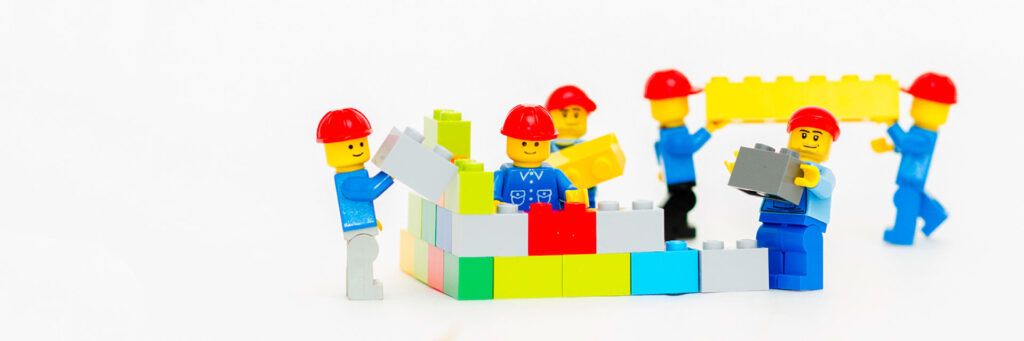 Seis bonecos de lego empilhando peças, rementendo a como a empresa pode gerenciar o FAP e economizar