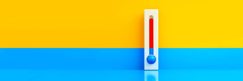 ermômetro em fundo colorido simbolizando mudança climática e variações de temperatura.